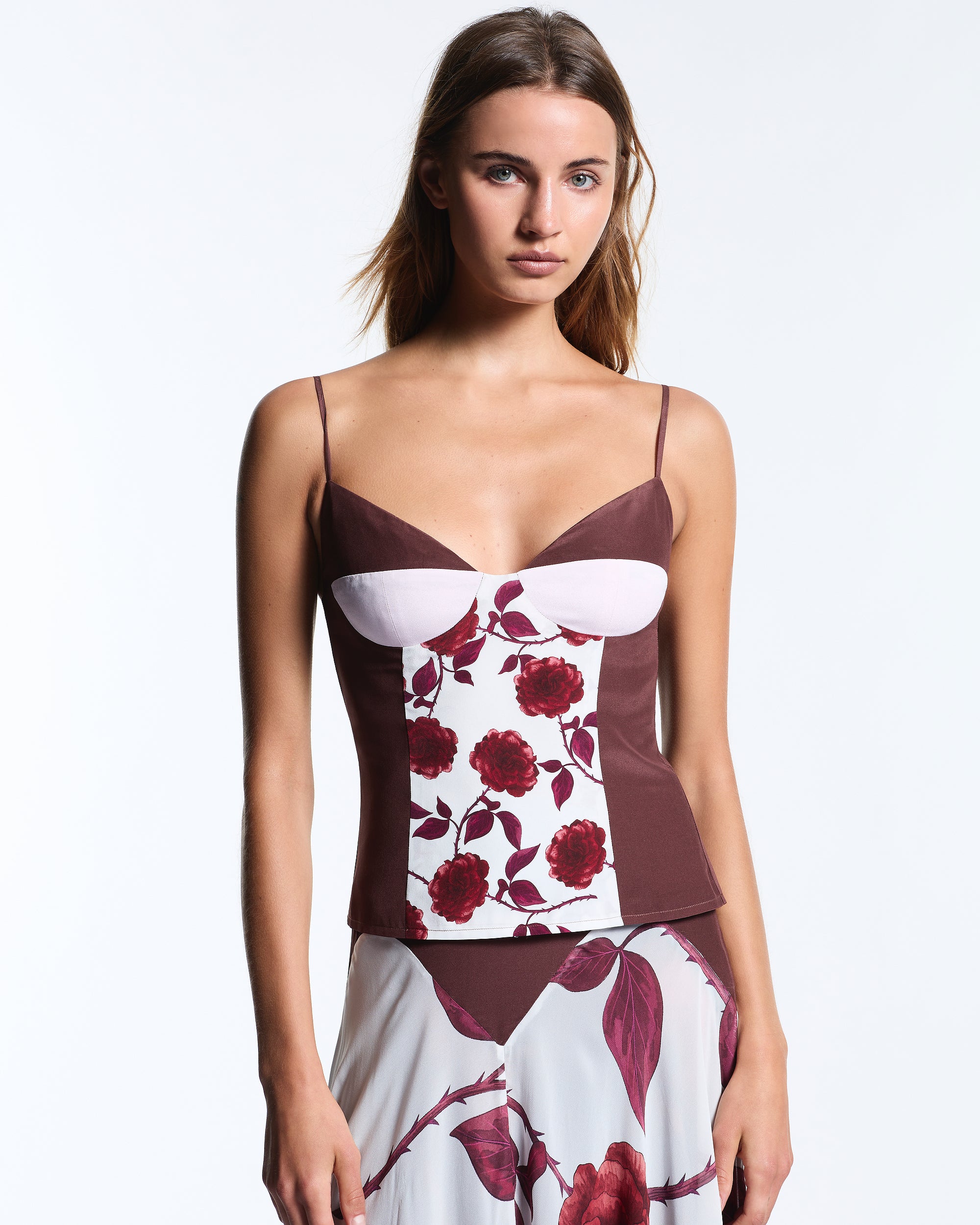 Woman wearing a floral top with a plain background